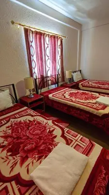 a hotel room with two beds with red and white blankets at Rocky Mountain Hotel Jordan in Petra