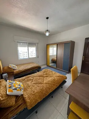 a room with three beds and a table and chairs at 2bedroom-2bathroom-furniture in Amman
