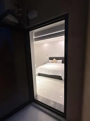 a view of a bedroom through a glass window at ريڨا للأجنحة السكنية Riva suites in Irbid