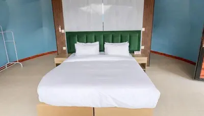 a large white bed with a green headboard in a room at Aseel camp rum in Wadi Rum