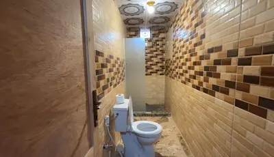 a bathroom with a toilet in a room with tiles at Aseel camp rum in Wadi Rum