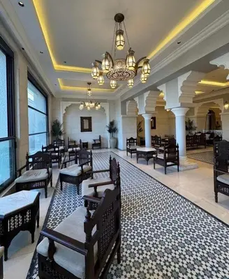 a lobby with chairs and tables and a chandelier at Luxury apartment for rent in BoulevardAirport Road in Amman