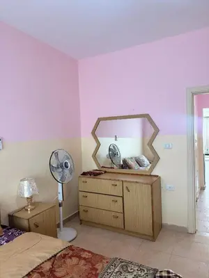 a bedroom with a mirror and a dresser with a fan at Seaview horizon apartment in Sowayma