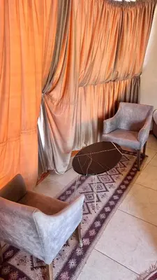 two chairs and a table in front of a curtain at Wadi Rum Desert Memory in Wadi Rum