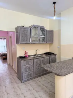 an empty kitchen with gray cabinets and a sink at panorama sea view apartment in Sowayma
