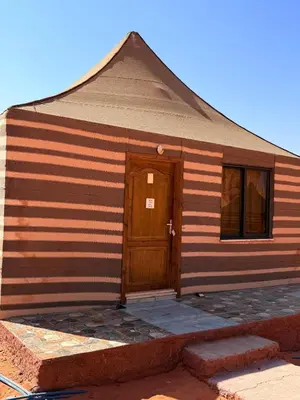 a house with a wooden door and a window at Desert Moon Camp in Wadi Rum