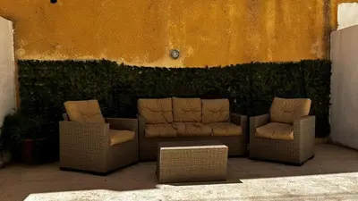 two wicker chairs and chairs sitting next to a wall at 1 bedroom Studio in 7th circle area in Amman