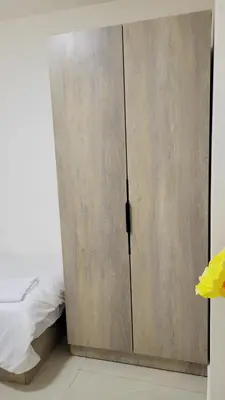 a bedroom with a wooden cabinet next to a bed at Lavender Résidence in Amman