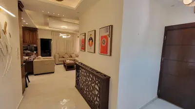a hallway with a staircase leading to a living room at Lavender Résidence 102 in Amman