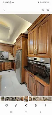 a kitchen with wooden cabinets and a stainless steel refrigerator at Lavender Résidence 102 in Amman