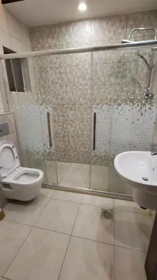 a bathroom with a shower and a toilet and a sink at La Perla Apertment Family in Amman