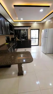 a kitchen with a counter and a refrigerator at La Perla Apertment Family in Amman