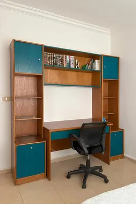 an office with a desk and a chair and book shelves at Comfy Apt at Jandawil -only Families- in Amman