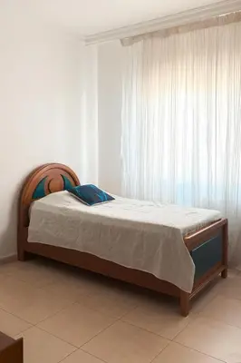 a bed sitting in a room with a window at Comfy Apt at Jandawil -only Families- in Amman
