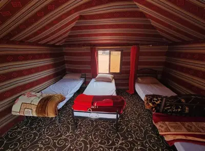 a room with three beds and a window at Wadi Rum Moon Light in Wadi Rum