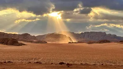 a sunset in the desert with the sun shining at Rum Cave Tours in Wadi Rum