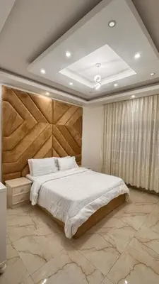 a bedroom with a large bed with a wooden headboard at شقق فندقيه فخمه للايجار اليومي in Ash Shumaysānī
