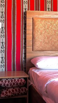 a bedroom with a bed and a nightstand next to a bedsenalsenalsenal at wadi rum Bubble lunara luxury camp in Wadi Rum