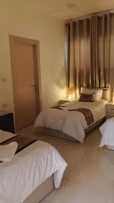 a bedroom with two beds and a window at hotel amman in Amman