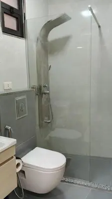 a bathroom with a shower with a toilet and a glass door at hotel amman in Amman