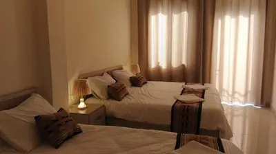 a bedroom with two beds and a window with curtains at hotel amman in Amman