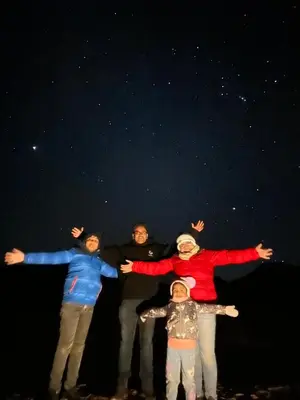 a group of people standing in front of the stars at Rum Ronza Luxury Camp in Maḩaţţat Dīsah