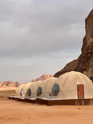 a row of domed buildings in the desert at Rum Ronza Luxury Camp in Maḩaţţat Dīsah