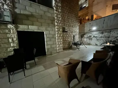 a large room with a stone fireplace and chairs at Cozy 1BR in Abdoun Quiet Near US Embassy in Amman