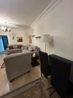 a living room with a couch and a table at Cozy 1BR in Abdoun Quiet Near US Embassy in Amman