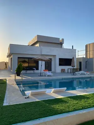 a swimming pool in front of a house at شاليه الدرة Durra Chalet in Amman