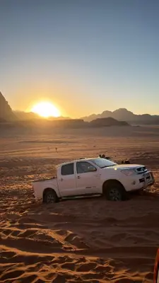 a white truck parked in the desert at sunset at HALA RUM Luxury camp & Bubbles Hotel in Disah