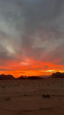 a sunset in the desert with mountains in the background at HALA RUM Luxury camp & Bubbles Hotel in Disah