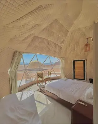 a bedroom with two beds and a large window at Mohammad rum camp in Disah