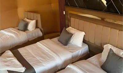 two beds in a room with white sheets and pillows at Mohammad rum camp in Disah