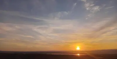 a sunset with the sun in the sky at Panoramic GUESTHOUSE - OUM ALI in Aş Şāfī