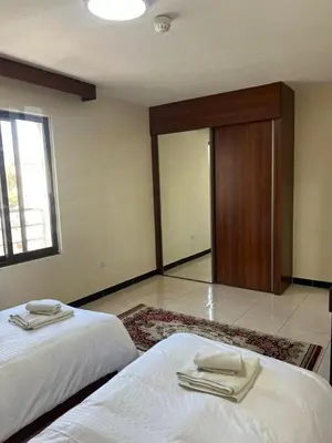 two beds in a room with two towels on them at Badan Suites & Hotel in Amman