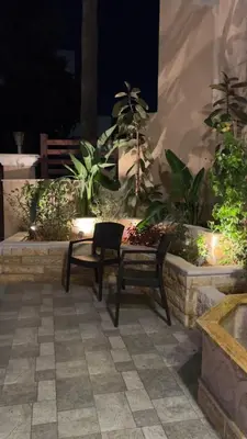 a chair and a bench in a courtyard with plants at مطر in Amman