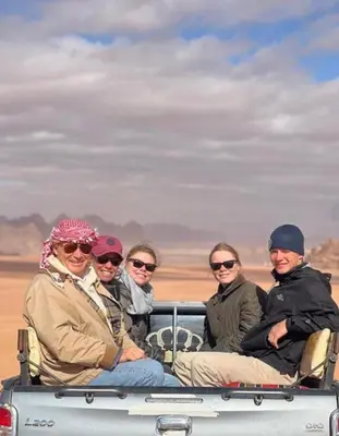 a group of people sitting in the back of a truck at Rum luxury camp hotel in Wadi Rum