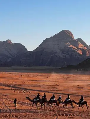 a group of people riding horses in the desert at Rum luxury camp hotel in Wadi Rum
