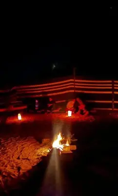 a fire pit in the sand at night at Rum luxury camp hotel in Wadi Rum