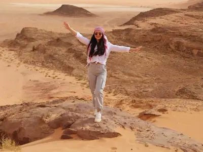 a woman standing on a rock in the desert at Wadi rum fun time in Wadi Rum