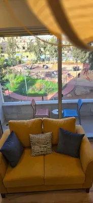 a couch sitting in a room with a large window at Rainbow 7 in Amman