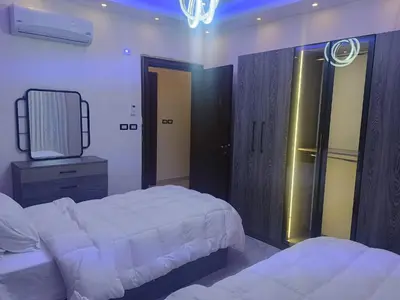 a bedroom with two beds and a television in it at شقق في عمان in Al Jafr