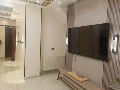 a flat screen tv hanging on a wall in a room at شقق في عمان in Al Jafr