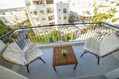 a balcony with two chairs and a table on a balcony at The FWD Living - FWD2 in Amman