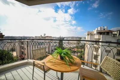 a table and chairs on a balcony with a view at The FWD Living - FWD2 in Amman