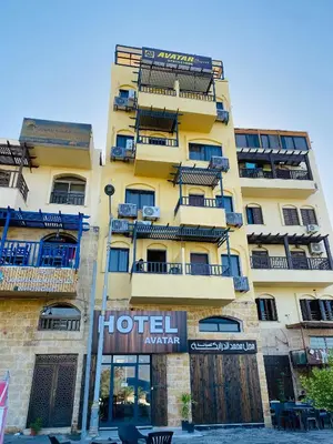 a tall yellow building with balconies on it at Avatar Hotel-Aqaba in Aqaba