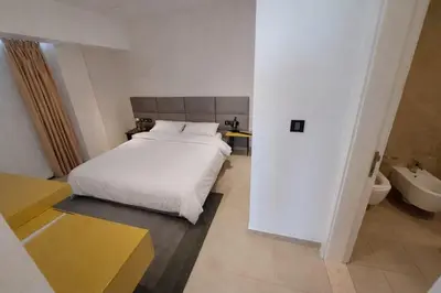 a bedroom with a white bed and a bathroom at Skyline Residence Apartment Stunning City Views in Amman