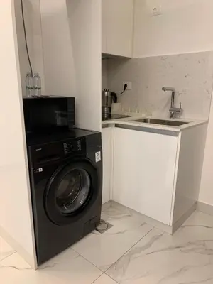 a kitchen with a washing machine and a sink at Boulevard Comfort Haven, apt with stunning veiw in Amman