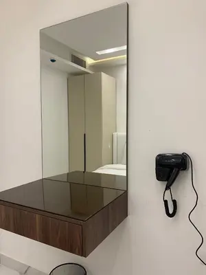 a mirror on a wall next to a phone at Boulevard Comfort Haven, apt with stunning veiw in Amman